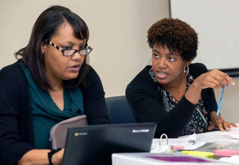 Two educators work together at a table