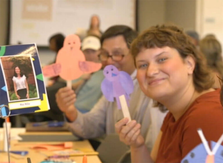 parents hold up paper cut outs
