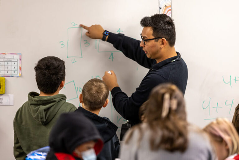 teacher at whiteboard with students