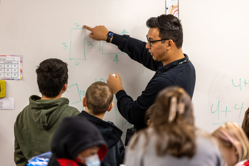 teacher at whiteboard with students