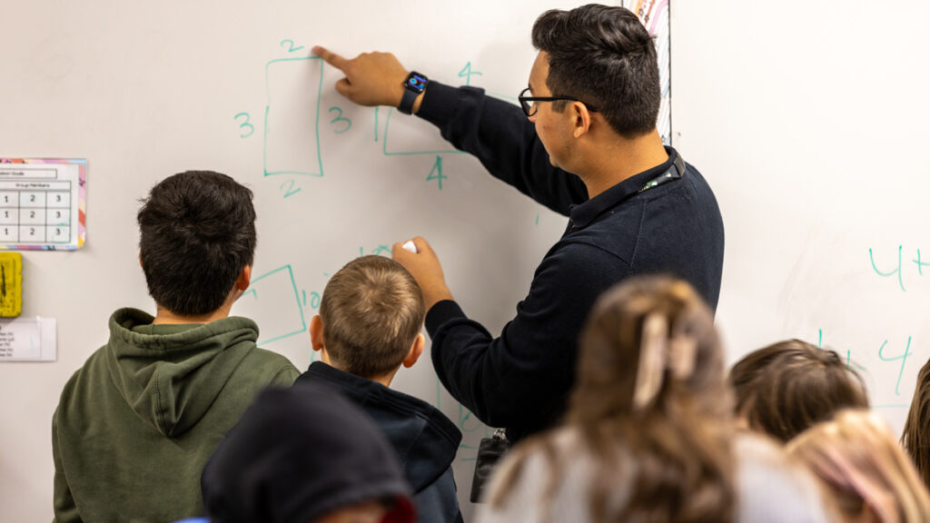Teacher writes on whiteboard