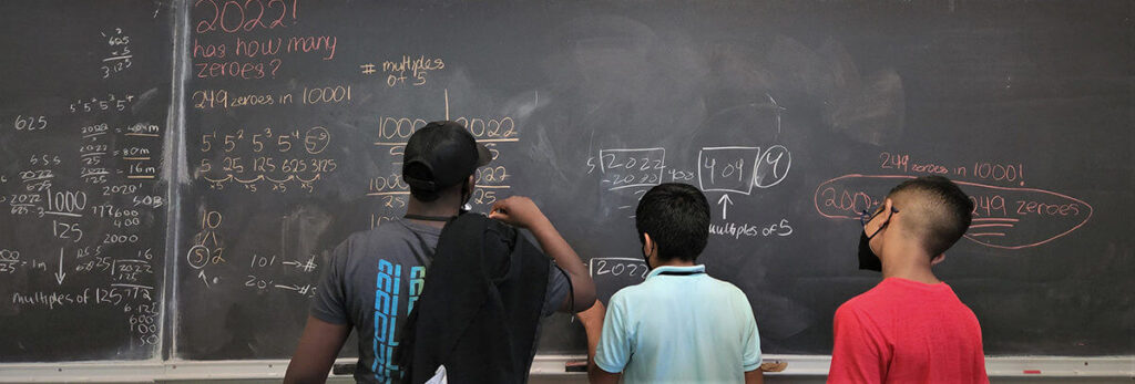 students write on chalkboard