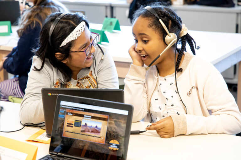 Two girls talking while wearing headphones