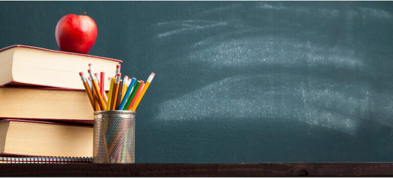Erased Blackboard, Stack of Books, Apple, and Pencils