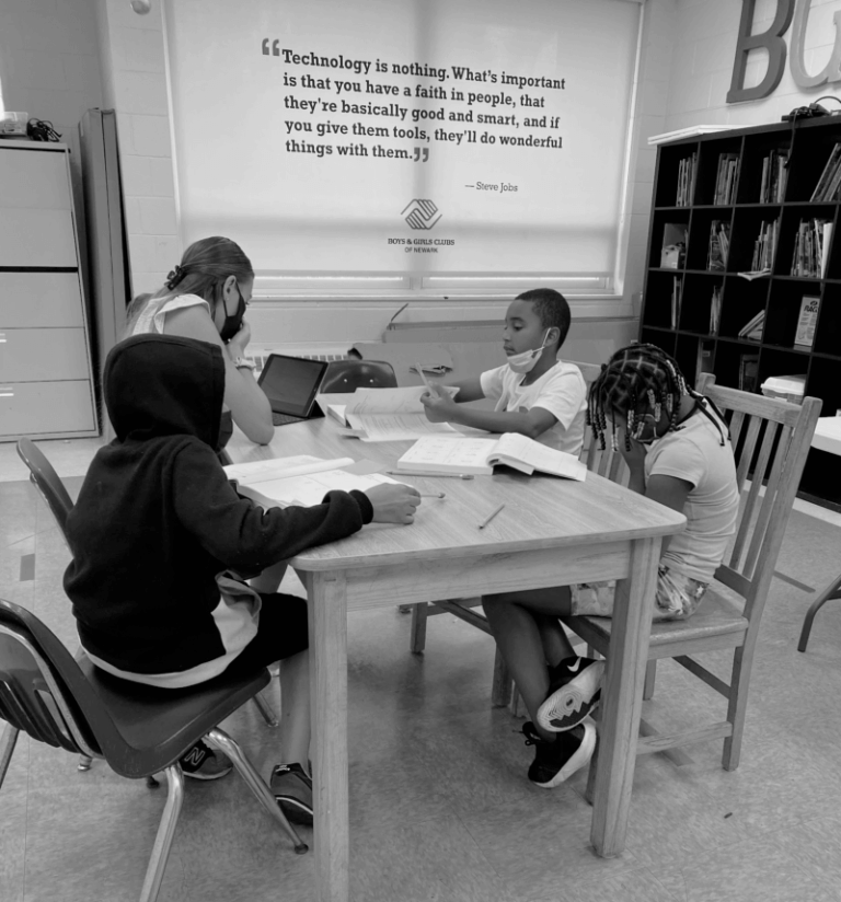students sit at table in tutoring