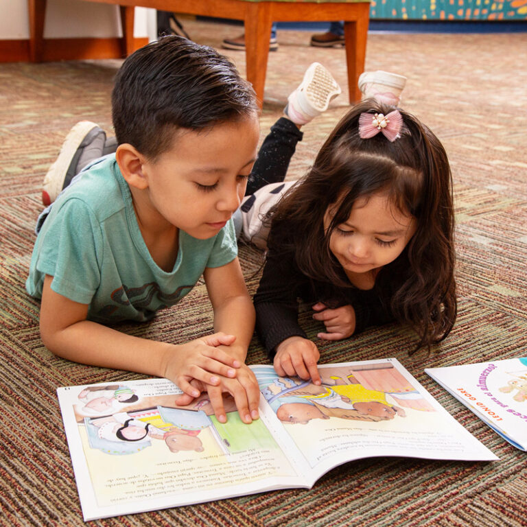 Two children read a book