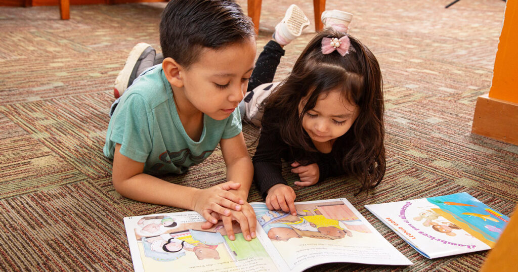 Two children read a book