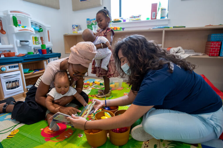 two adults hold baby
