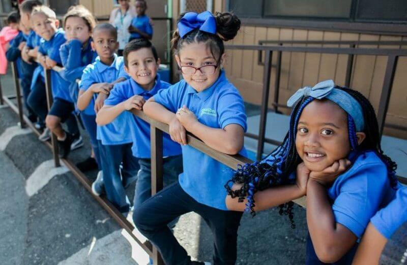 Students stand at railing in school uniforms