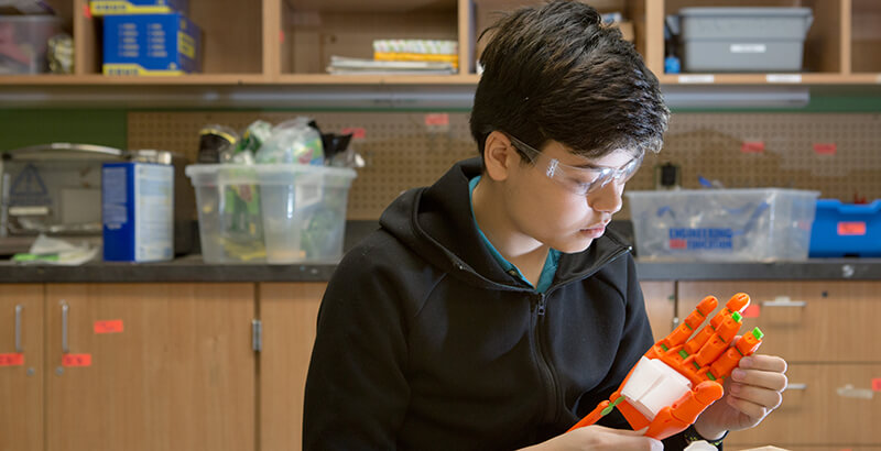 An engineering student constructs a robotic hand for a project