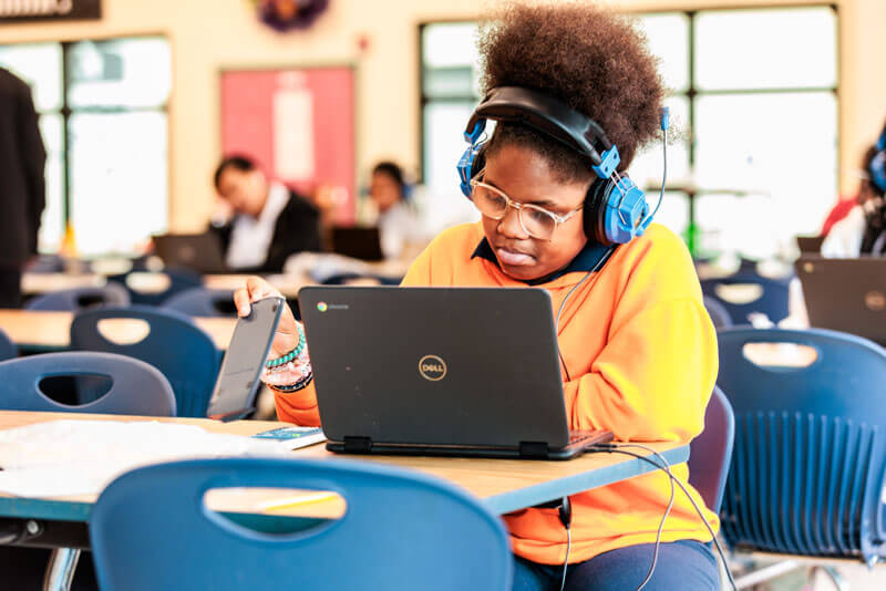 Student sits at desk with laptop