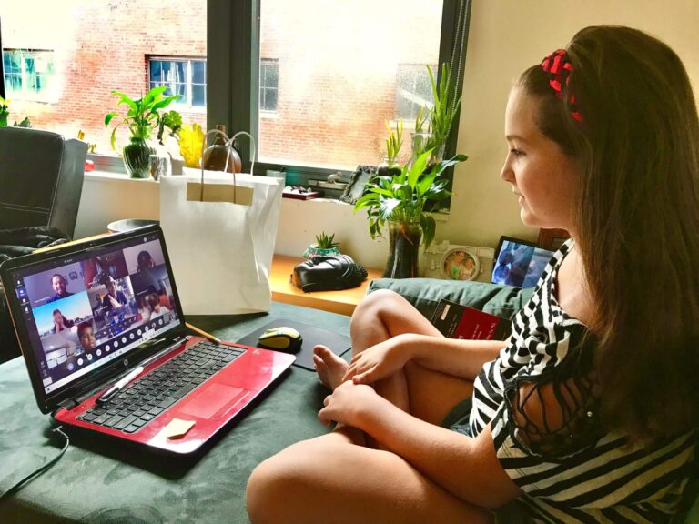 student talks to people using a laptop