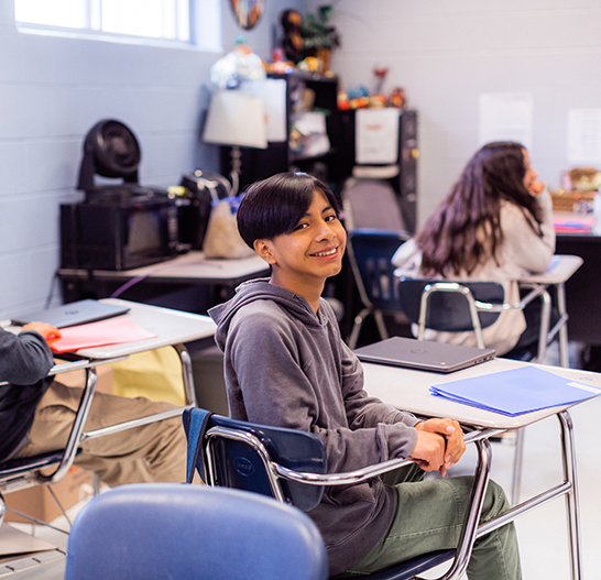 Young boy sits in desk at school