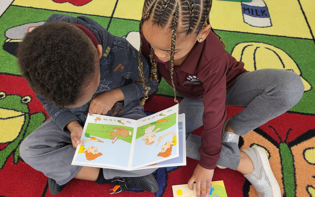 Two children reading book