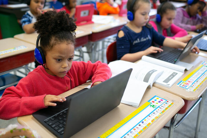 Young students sit at desks in classroom