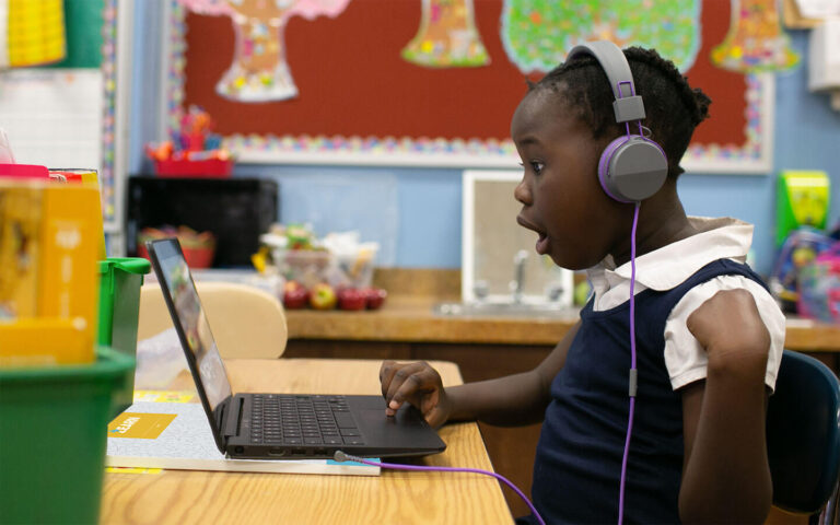 Young student works on laptop in classroom