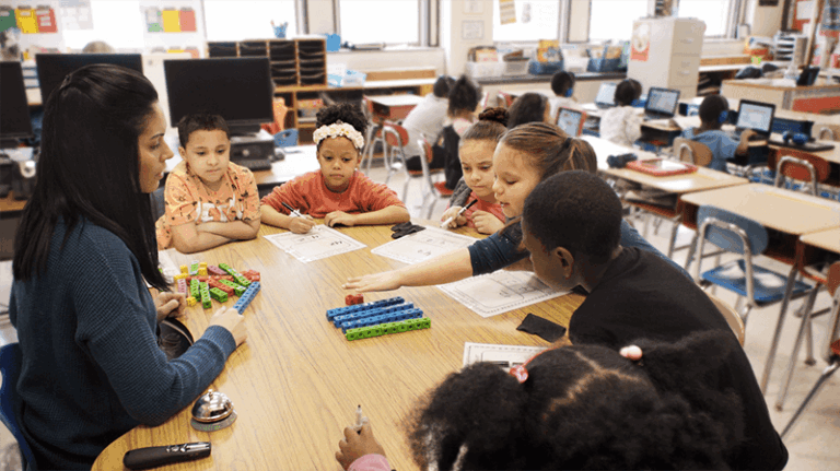 students sit at table in classroom
