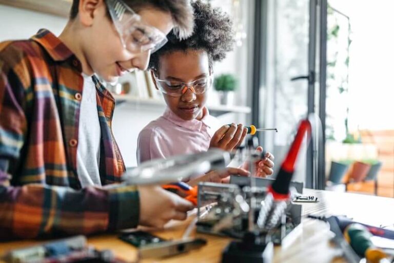 two children wearing goggles work on project