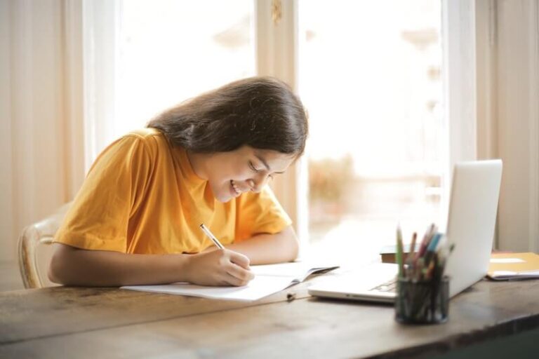 woman-in-yellow-shirt-writing-on-white-paper