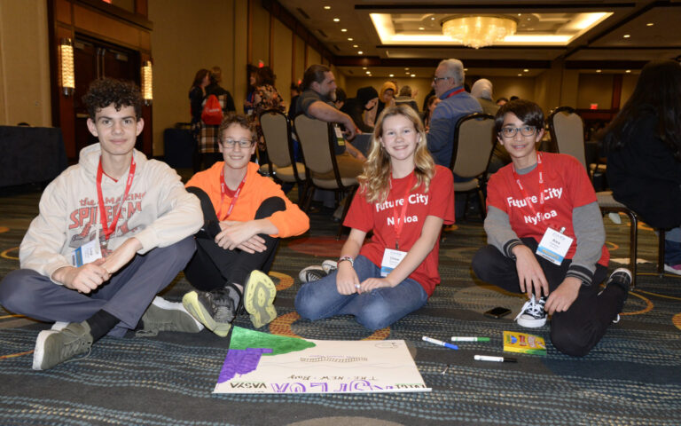 four students sit on floor in DiscoverE program