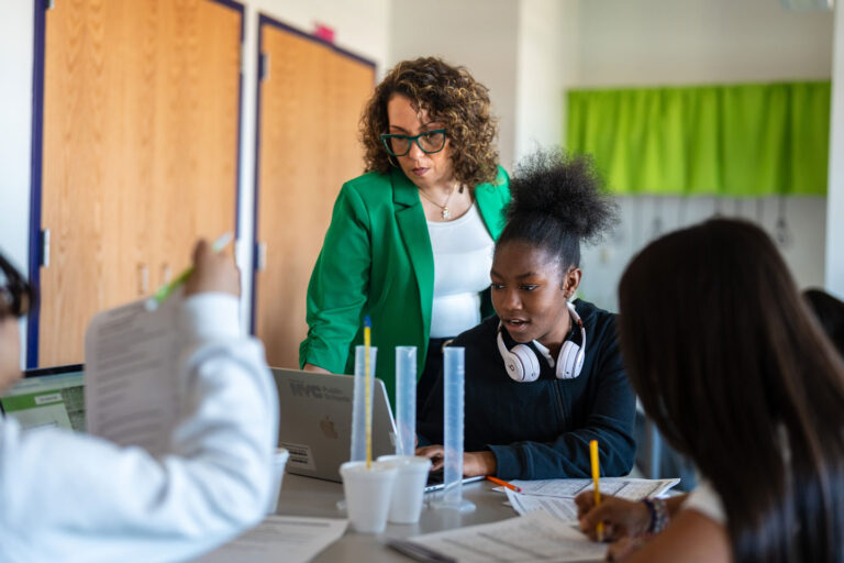 Educator works with student in classroom