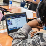 student works virtually with tutors on a laptop