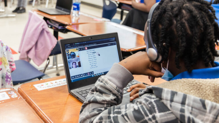 student works virtually with tutors on a laptop