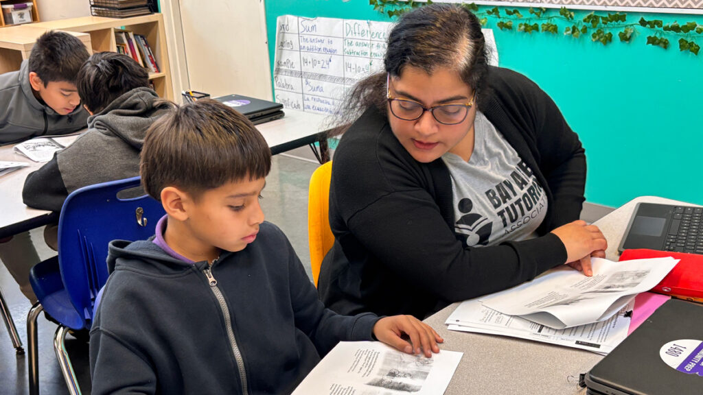 tutor works with student in classroom