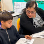 tutor works with student in classroom