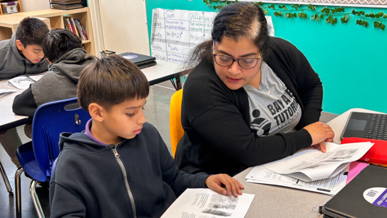 tutor works with student in classroom