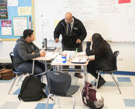 Educator works with two students