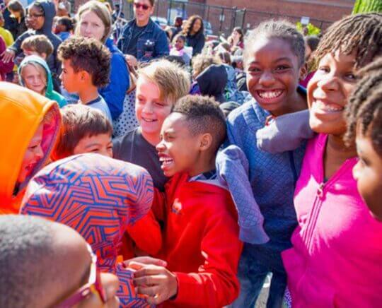 Large group of children celebrating in schoolyard. Image provided by Campaign for Grade Level Reading.
